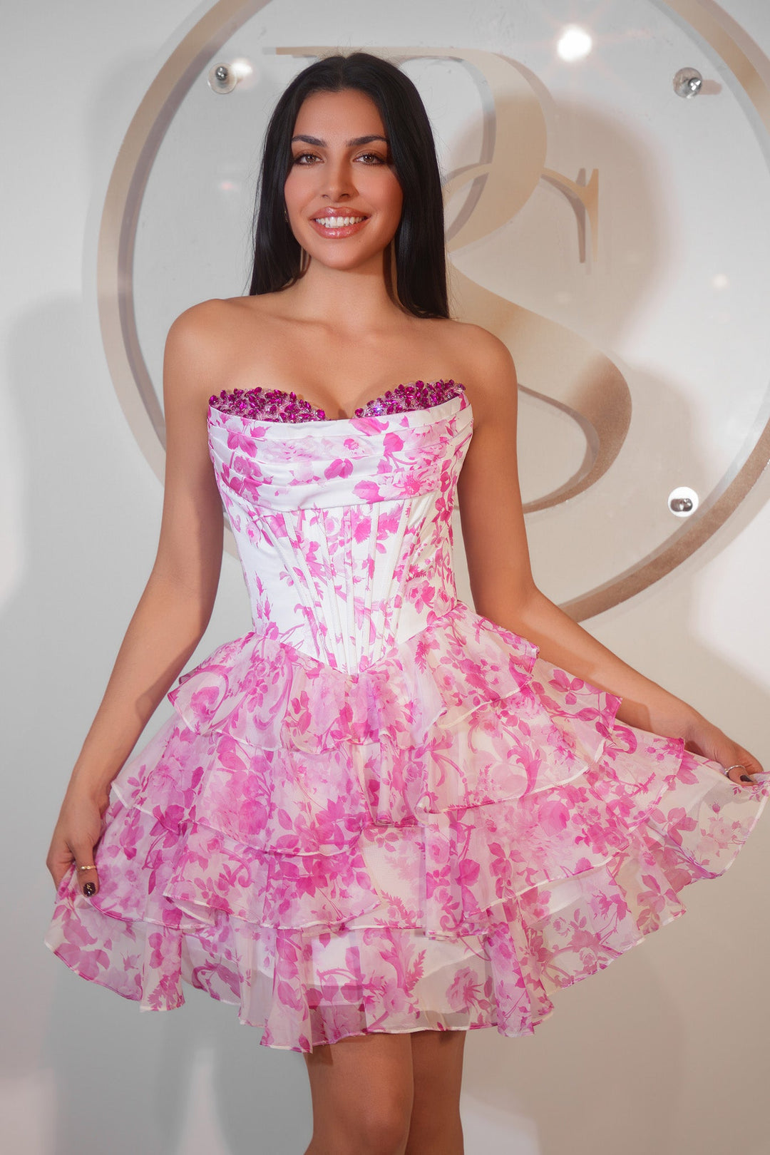 Woman wearing a strapless pink and white floral dress with a blurred background